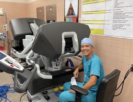 Dr. Le sits at the surgical robot's console,  where he performs minimally invasive chest surgeries on patients