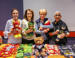 four elderly women holding teddy bears