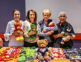 four elderly women holding teddy bears