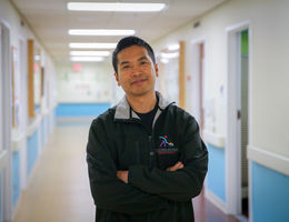 physician standing in empty hospital hallway