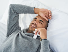Man lying in bed with a headache