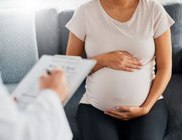 Shot of a pregnant young woman talking with doctor