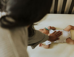 Mother looking after a sleeping baby in crib