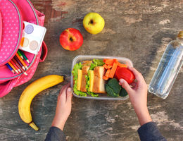 Sandwiches, fruits and vegetables in food box, backpack on old wooden background. Concept of child eating at school. Top view. Flat lay.