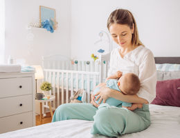 mother breastfeeding her baby in at-home nursery