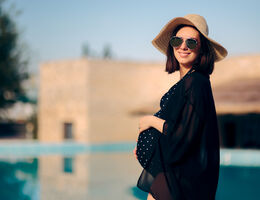 Pregnant Woman Relaxing on Vacation By The Pool