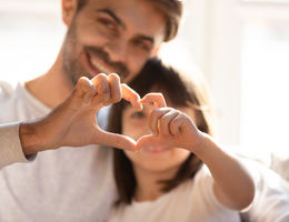 Family members form a heart with their hands.