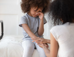 mixed race mom comforts young daughter