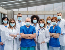 Group of doctors with face masks looking at camera, corona virus concept