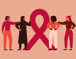 Four women of various races and ethnicities stand gathered around the breast cancer awareness ribbon