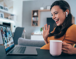 pregnant woman having video online meeting using her laptop and Wireless earbuds at home