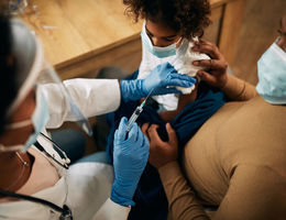 Close-up of doctor vaccinating African American girl during coronavirus pandemic