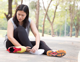 Female holding her ankle in pain