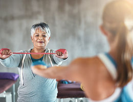 Woman exercising arms during a class while facing another woman