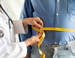 Obese man being measured by doctor