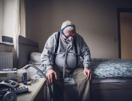 Elderly Man Using a Medical Breathing Apparatus stock photo
