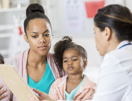 mother and young daughter discussing medical test results with doctor