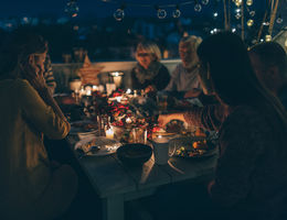 multigenerational family enjoys outdoor thanksgiving meal together after dark