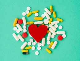 Heart cutout on backdrop of medical pills