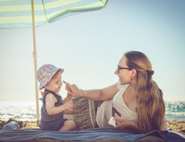 Young mother applying sunblock cream on her baby