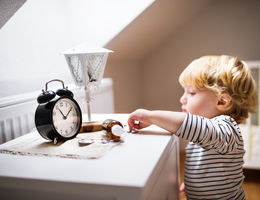 toddler boy reaching for pills on nightstand