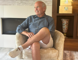 When left untreated, Normal Pressure Hydrocephalus can lead to dementia White man in a blue button up shirt and white shorts sits in a yellow chair in front of a fireplace