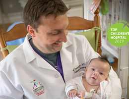 physician holds infant patient