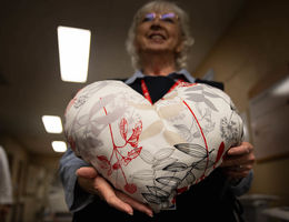 woman holds heart pillow
