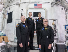While at NASA, four volunteers stand in front of the simulated shuttle they participated in for. 45 days. 