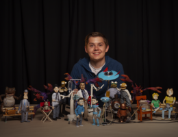 young man poses with claymation characters