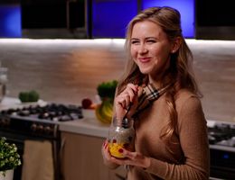 blonde Caucasian woman eating in kitchen