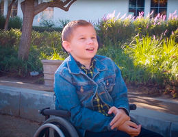 adolescent boy sitting outside in wheelchair