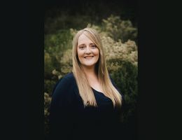 Headshot photo of Blonde Caucasion woman wearing black