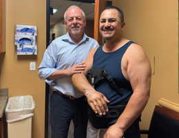 A doctor stands with a patient in recovery from an accident