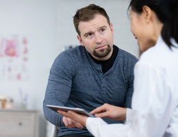 man sitting with a doctor