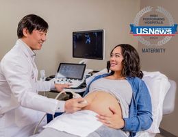 Caucasian woman with brown hair receives a prenatal ultrasound from a doctor of Asian decent