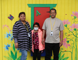 hispanic female pediatric patient poses for photo with her mother and father