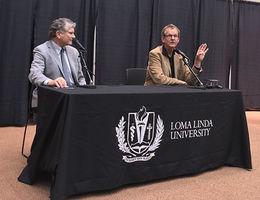 Professor of Religion James Walters, PhD, left, and guest speaker Philip Clayton, PhD, took questions from the audience after Clayton’s plenary address during the conference “What’s with Free Will? Ethics and Religion after Neuroscience.” Two men sit at table with microphones