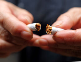 man holding broken cigarette