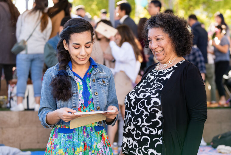 Young woman and her mom opening an envelope.