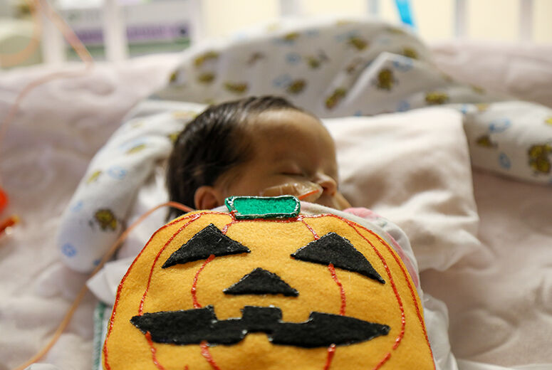 female infant with felt pumpkin costume