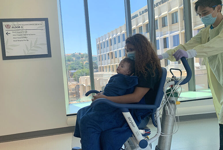 mom and child in wheelchair being moved to new hospital