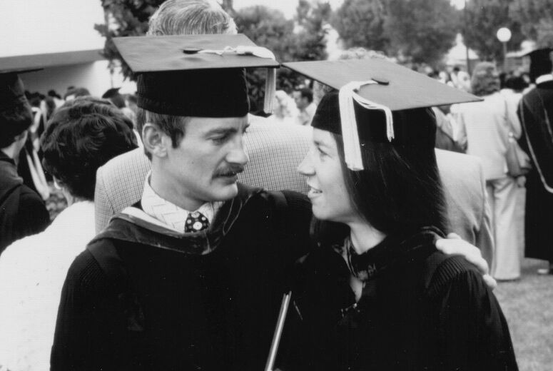 black and white photo of a male and female graduate in cap and gown.