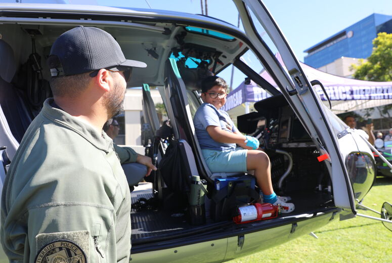 A police officer from the Riverside Police Department smiles as a young patient sits inside the cockpit of a police helicopter during the 24th Annual Cops for Kids Fly-In at Loma Linda University Children’s Hospital.