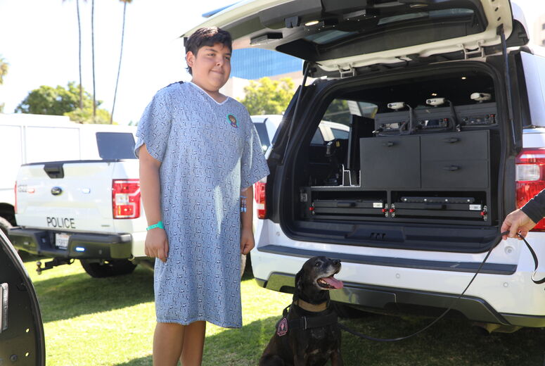 Young patient smiles next to K9 trained in drug detection