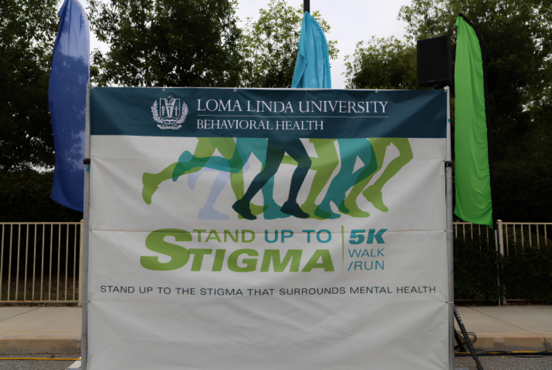 Banner for Loma Linda University Behavioral Health “Stand Up to Stigma” 5K Walk/Run displayed outdoors