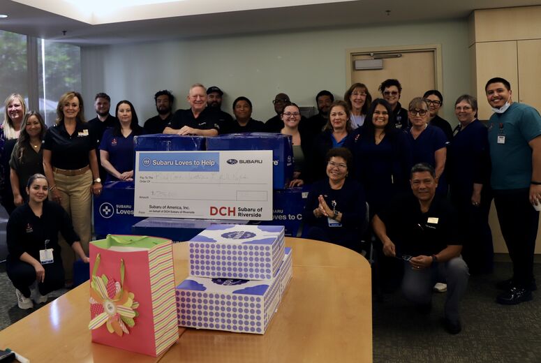a group of people pose next to a check