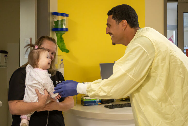 Jaelan reaches out to hold baby patient
