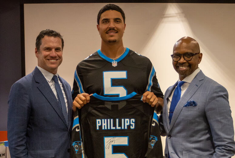 Jaelan poses with jersey alongside two LLUH administrators
