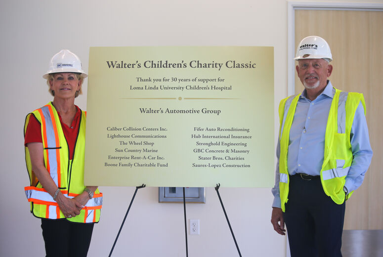 Steve and Cathy Kienle stand beside presentation sign